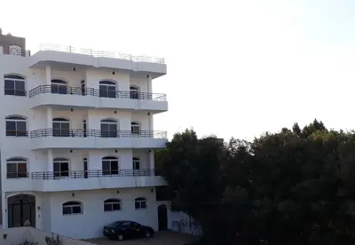 a white building with a car parked in front of it at New Modern Flats in Luxor