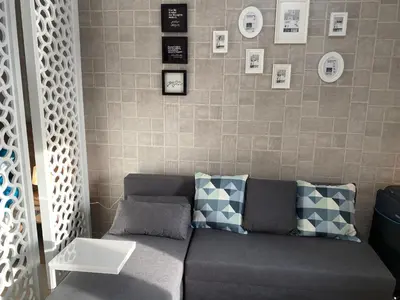 a couch in a living room with pictures on the wall at Awesome Pool View Studio in Al Dau Heights in Hurghada
