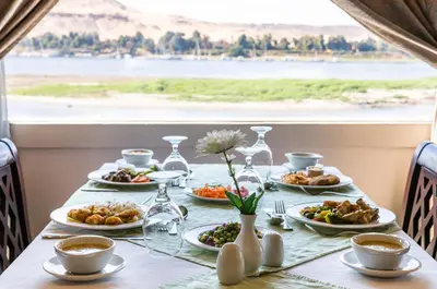 a table with plates of food on it with a view at MS Chateau Lafayette Nile Cruise - 4 nights from Luxor each Monday and 3 nights from Aswan each Friday in Luxor