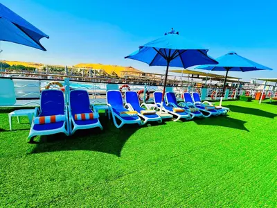 a group of blue chairs and umbrellas on the grass at MS Chateau Lafayette Nile Cruise - 4 nights from Luxor each Monday and 3 nights from Aswan each Friday in Luxor
