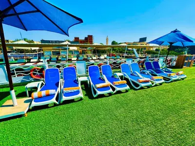 a row of blue lounge chairs sitting on the grass at MS Chateau Lafayette Nile Cruise - 4 nights from Luxor each Monday and 3 nights from Aswan each Friday in Luxor