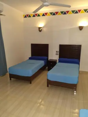 a room with two beds and a ceiling at ABAZIDO Nubian Guest House in Aswan