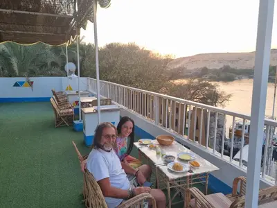 a man and a woman sitting at a table on a balcony at ABAZIDO Nubian Guest House in Aswan