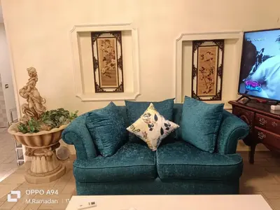 a living room with a blue couch and a tv at Villa with Private Pool in Hurghada