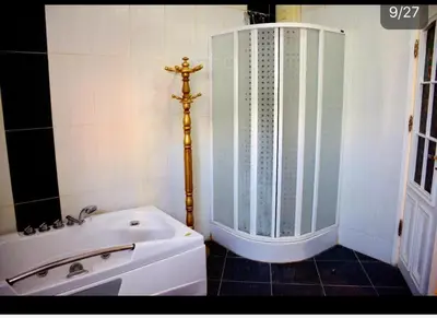 a bathroom with a shower and a white tub at Villa with Private Pool in Hurghada