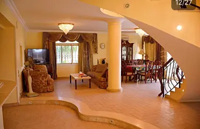 a large living room with a staircase and a dining room at Villa with Private Pool in Hurghada