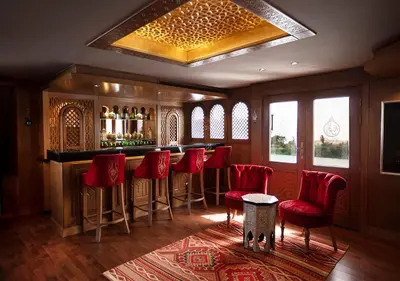 a bar with red bar stools in a room at Dahabeya Yakouta Nile Cruise-Every Monday from Luxor- Aswan for 05 nights in Luxor