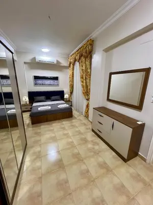 a large bedroom with a bed and a mirror at Karnak Flats in Luxor