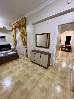 a large living room with a bed and a television at Karnak Flats in Luxor