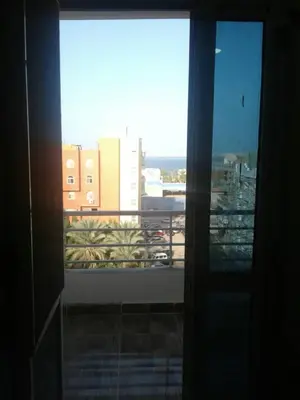 a window with a view of a city with buildings at Sea View Apartment at Sheraton Road 2 bed rooms in Hurghada