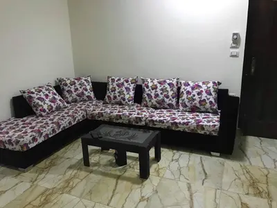 a black couch with pillows and a table in a room at Sea View Apartment at Sheraton Road 2 bed rooms in Hurghada