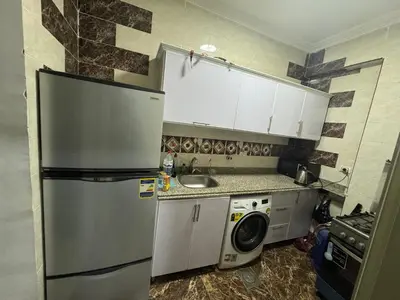 a kitchen with a refrigerator and a washing machine at Sea View Apartment at Sheraton Road 2 bed rooms in Hurghada