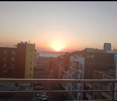 a sunset over a city with buildings and the ocean at Sea View Apartment at Sheraton Road 2 bed rooms in Hurghada