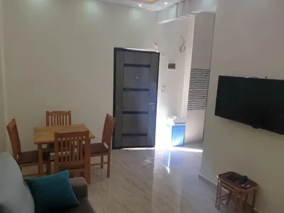a living room with a couch and a table and a television at Bravey Apartments in Hurghada