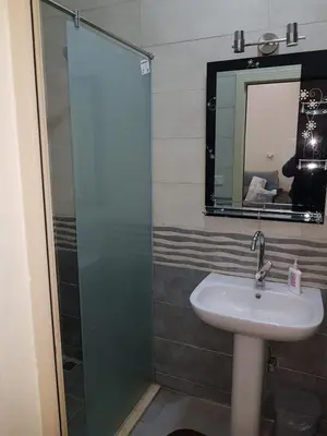a bathroom with a sink and a shower with a mirror at Bravey Apartments in Hurghada
