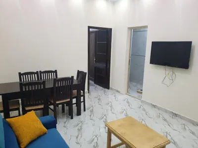 a living room with a couch and a table and a tv at Bravey Apartments in Hurghada