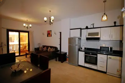 a living room with a kitchen and a dining room at BeachView Turtles in Hurghada