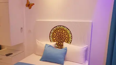 a bed with a yellow and white headboard with pillows at BeachView Turtles in Hurghada