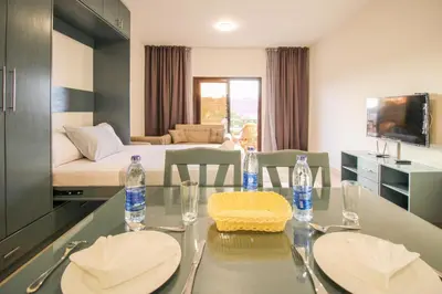 a room with a dining table with two chairs and a bed at BeachView Turtles in Hurghada