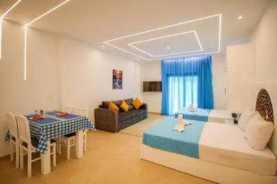 a bedroom with a bed and a table and a couch at BeachView Turtles in Hurghada