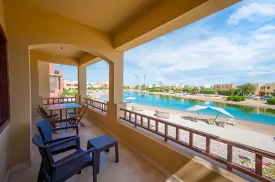 a balcony with two chairs and a view of a river at VESTA - El Gouna Residence in Hurghada