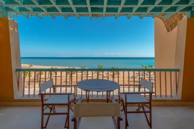 a table and chairs on a balcony with a view of the beach at VESTA - El Gouna Residence in Hurghada