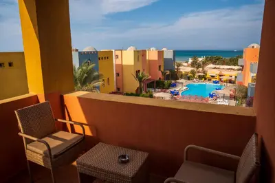 a balcony with chairs and a view of a resort at Al Dora Boutique Hotel in Hurghada
