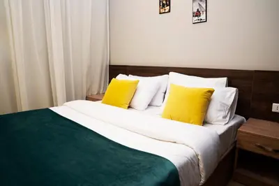 a bedroom with a bed with yellow and white pillows at Al Dora Resort Hurghada in Hurghada