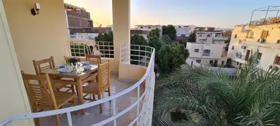 a balcony with a table and chairs on a balcony at Senmut Luxory Apartments in Luxor