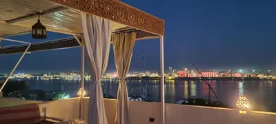 a balcony with a view of the water at night at Senmut Luxory Apartments in Luxor