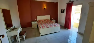 a bedroom with a bed and a desk and a window at Senmut Luxory Apartments in Luxor