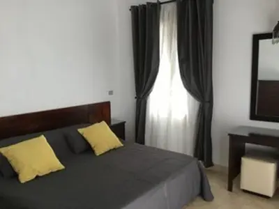 a bedroom with a bed with yellow pillows and a window at Villa - Sleeps 6 - Heated Pool - Garden - Parking in Hurghada
