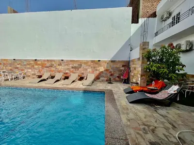 a swimming pool with chairs and a table next to a building at Spirit Luxor Luxury in Luxor
