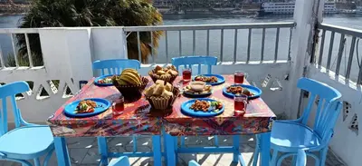 a table with plates of food on a balcony at Nuba Tod Abouda Guest House in Aswan