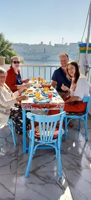 a group of women sitting around a table with food at Nuba Tod Abouda Guest House in Aswan