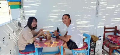 a man and a woman sitting at a table at Nuba Tod Abouda Guest House in Aswan