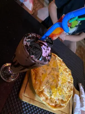 a milkshake in a glass jar sitting next to a pancake at Apartments in Florenza Khamsin in Hurghada