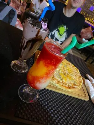 a table with two drinks and a pizza on it at Apartments in Florenza Khamsin in Hurghada