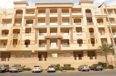a large building with cars parked in front of it at Apartments in Florenza Khamsin in Hurghada
