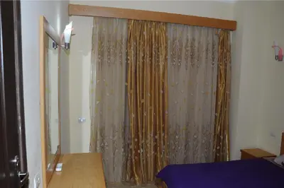 a bedroom with a bed and a curtain at Apartments in Florenza Khamsin in Hurghada