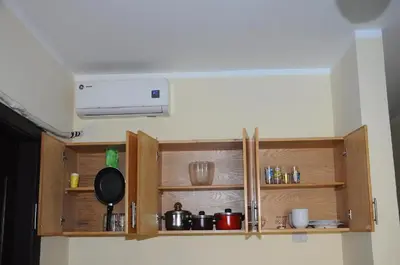 a kitchen with wooden cabinets with pots and pans at Apartment I in Florenza Khamsin in Hurghada
