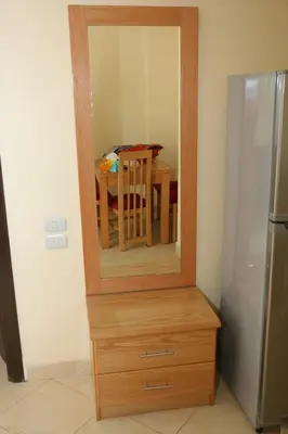 a mirror on top of a wooden dresser with a table at Apartment F in Florenza Khamsin in Hurghada