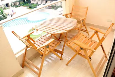 a table and chairs on a balcony with a pool at Apartment F in Florenza Khamsin in Hurghada