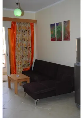 a living room with a black couch and a table at Apartment G in Florenza Khamsin in Hurghada