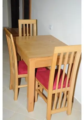 a wooden dining table and chairs with pink cushions at Apartment G in Florenza Khamsin in Hurghada