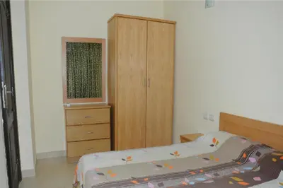 a bedroom with a bed and a wooden cabinet at Apartment G in Florenza Khamsin in Hurghada