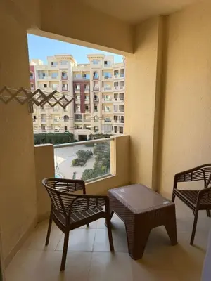 a balcony with two chairs and a table and a window at Studio H in Florenza Khamsin in Hurghada