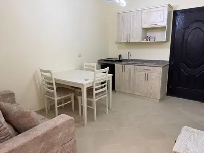 a kitchen with a table and chairs in a room at Studio H in Florenza Khamsin in Hurghada