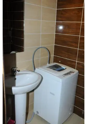a bathroom with a sink and a washing machine at Studio H in Florenza Khamsin in Hurghada