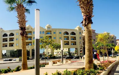 a building with palm trees in front of a street at Solider Dali in Hurghada